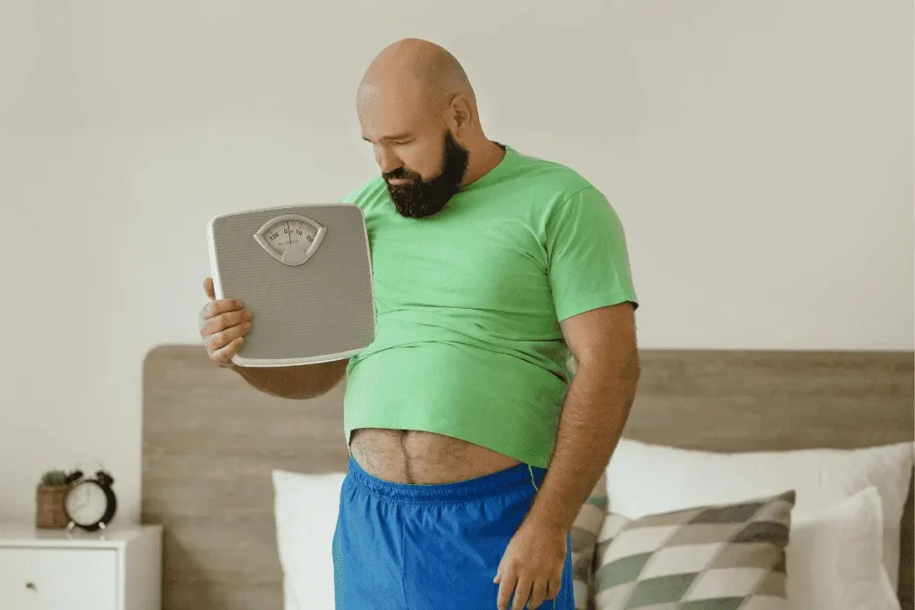 Bearded man checking bathroom scale in bedroom