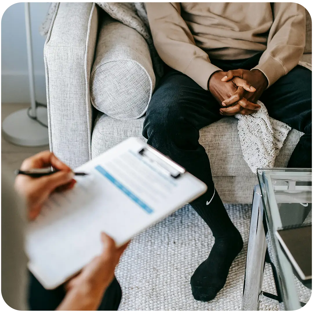 Therapy session: patient seated, clinician taking notes